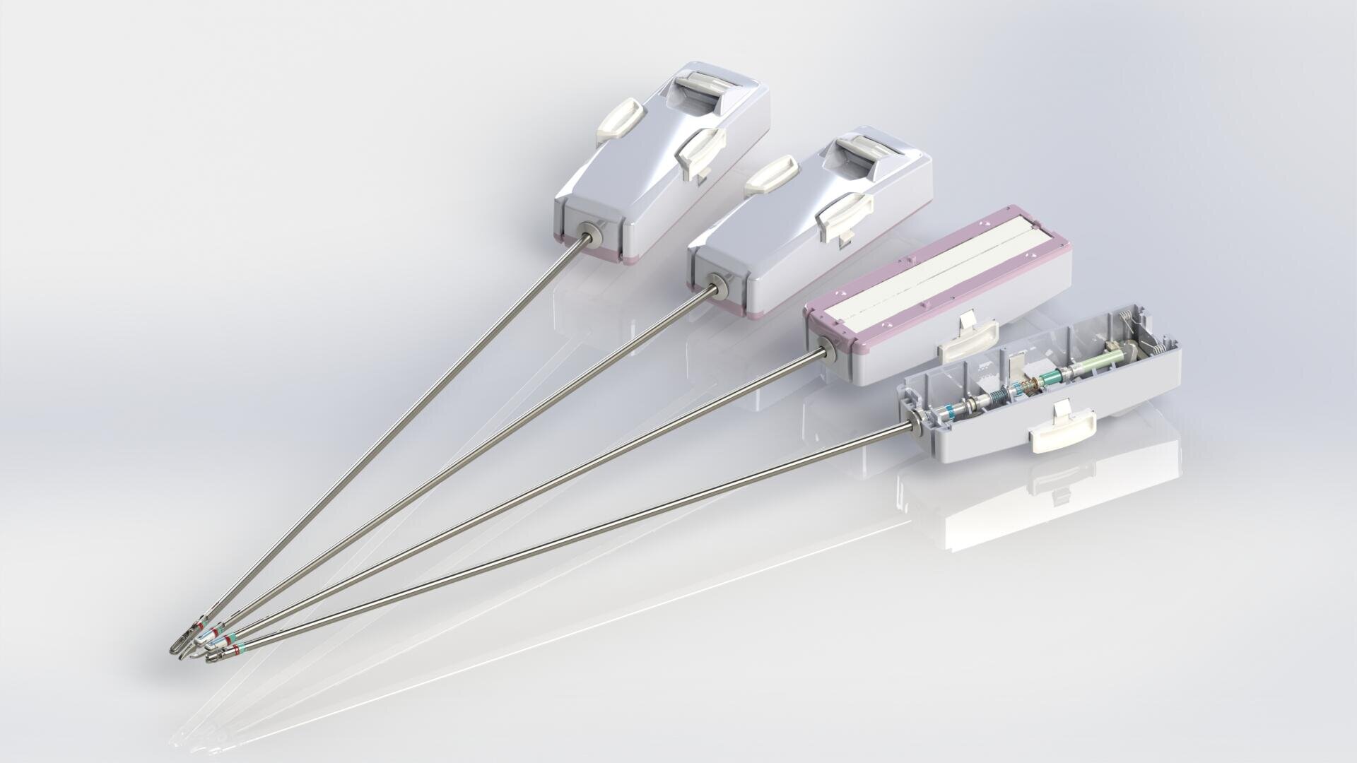 Three medical devices with long metal rods and rectangular, white plastic handles are displayed next to each other; the device on the right has a partially transparent housing that allows a view of the internal components.