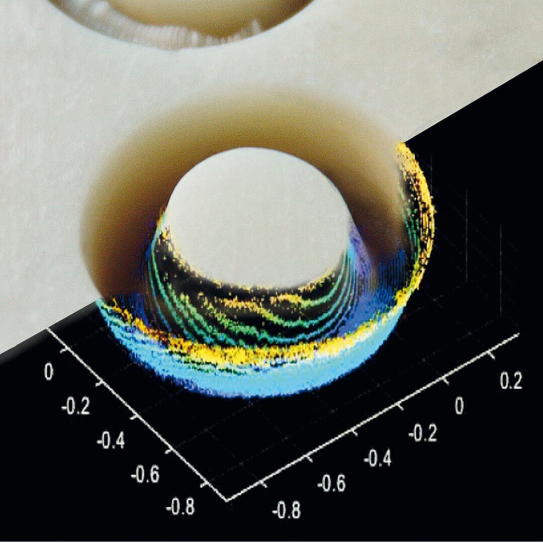 Ein 3D-Datendiagramm in Schwarz mit bunten Punkten unter einem beigen, halbtransparenten Ring, das einen mehrschichtigen, wissenschaftlichen Visualisierungseffekt mit Gitternetzlinien und numerischen Achsen erzeugt.