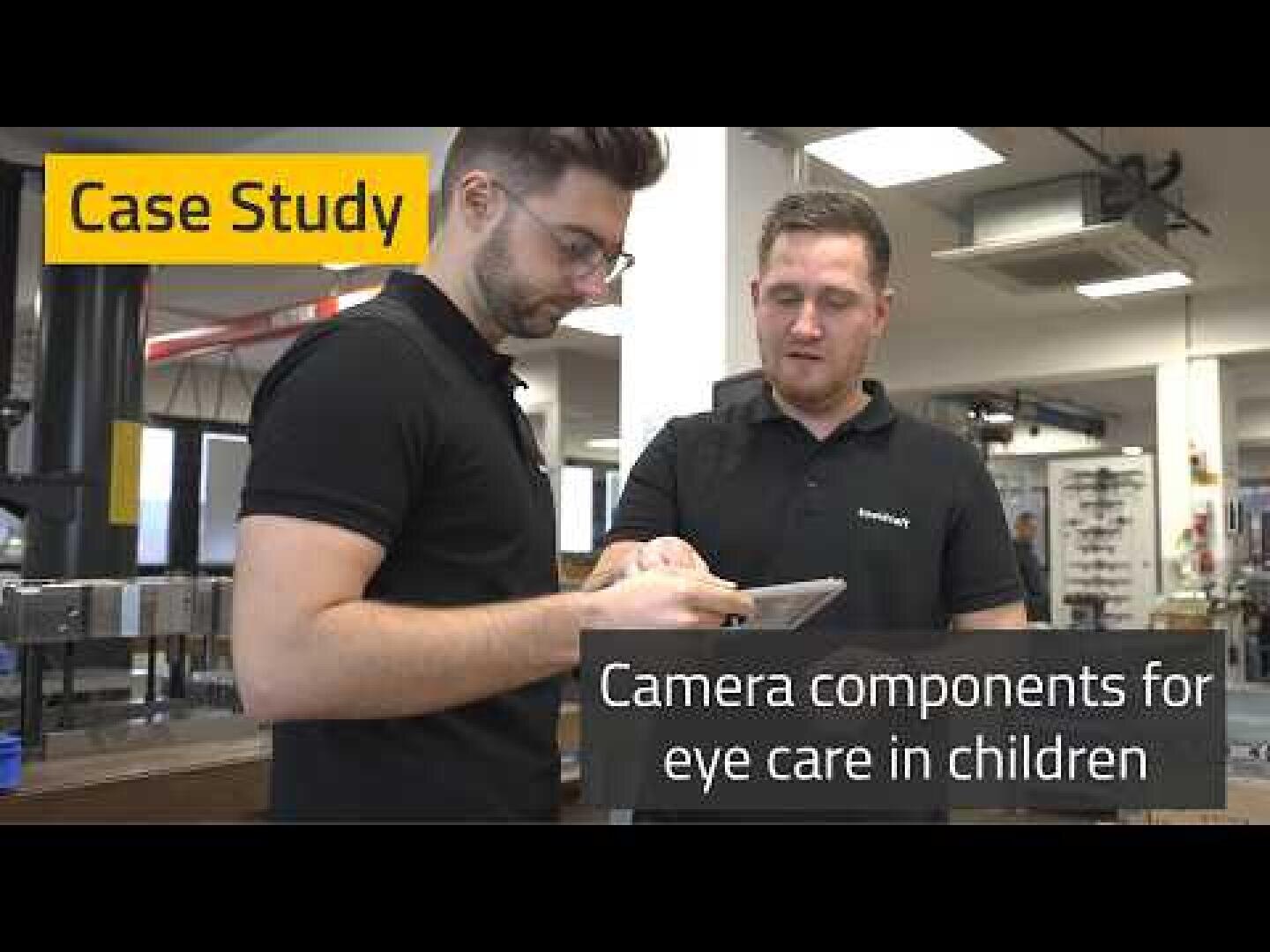 Two men wearing black shirts stand indoors, looking at a tablet together. Text on the image reads Case Study and Camera components for eye care in children.